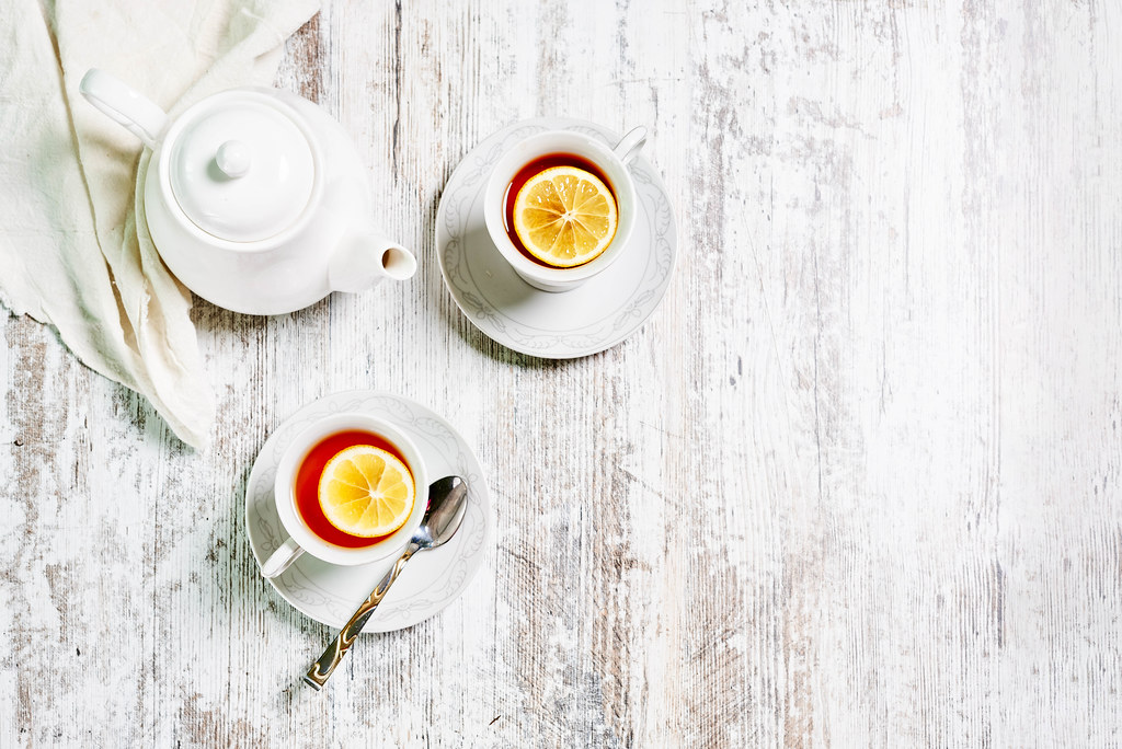 Hot earl grey tea with lemon slice on white wooden background