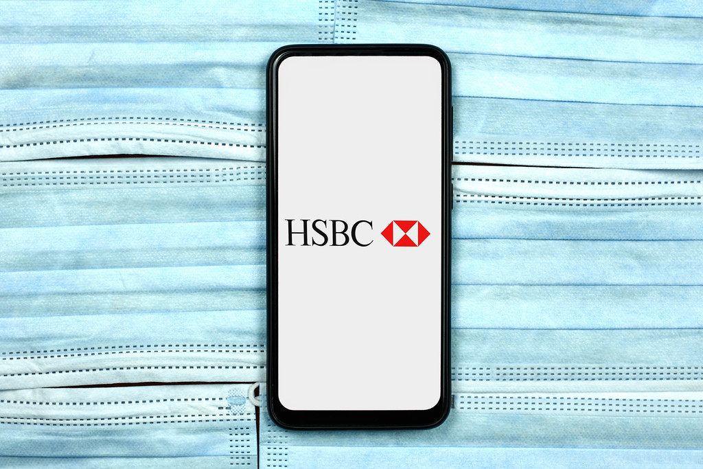 HSBC Investment banking company logo on smartphone screen over the face masks