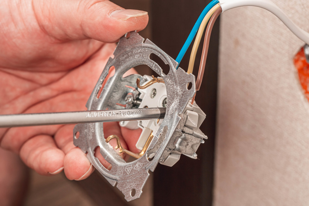 Installation wire into a plug, electrician connects the sockets to the electrical wires