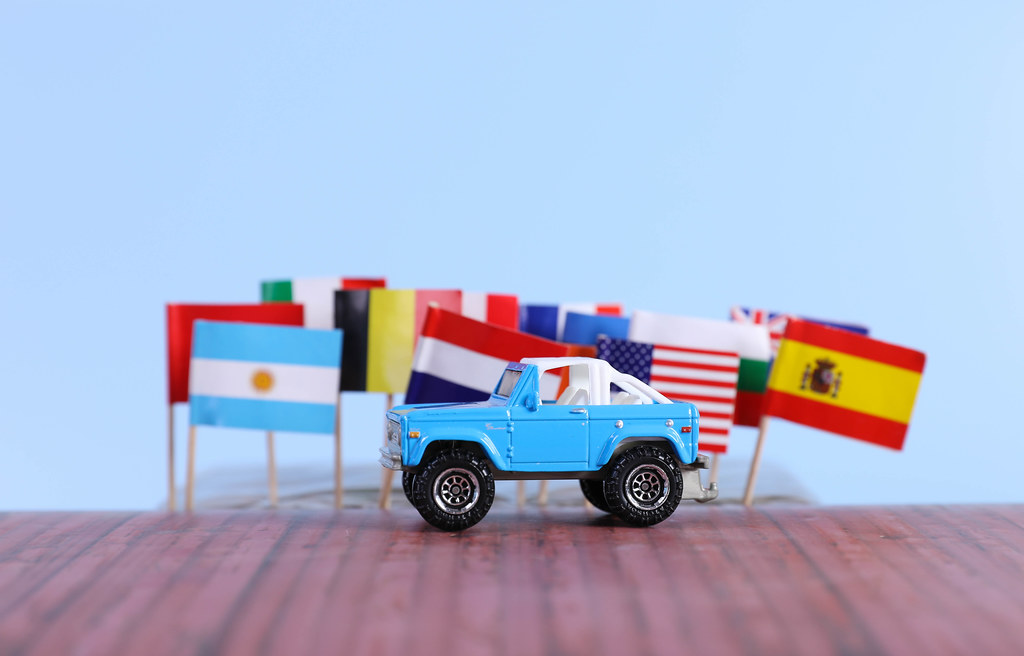 International flags and blue off road car
