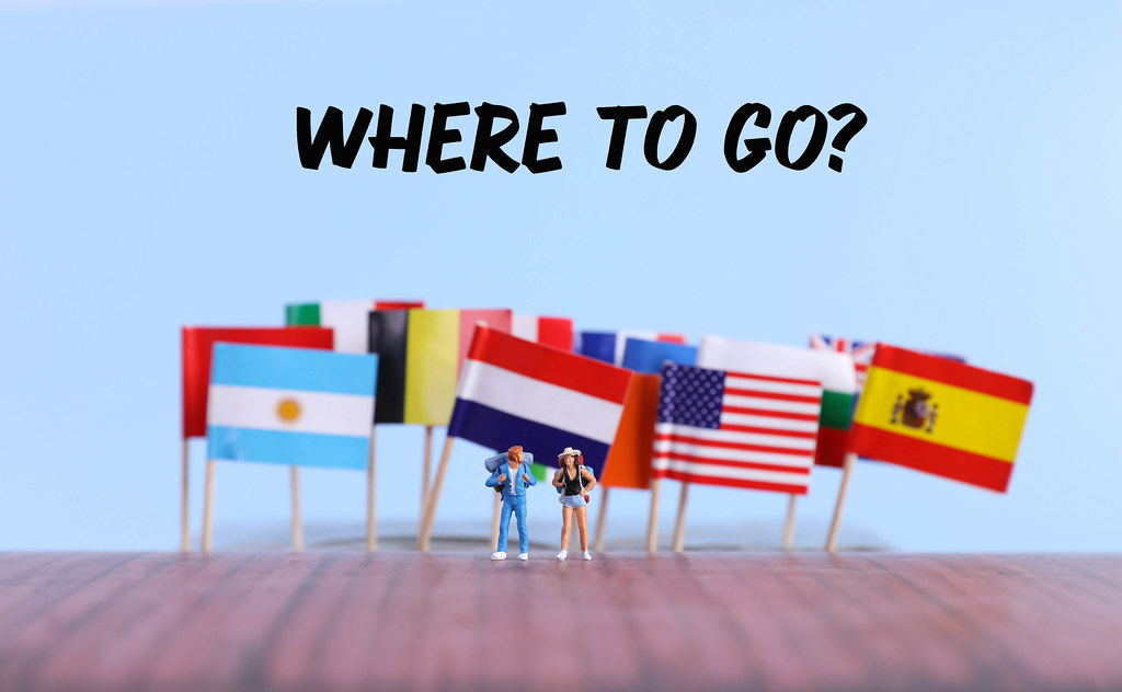 International flags with two travelers and Where to go text