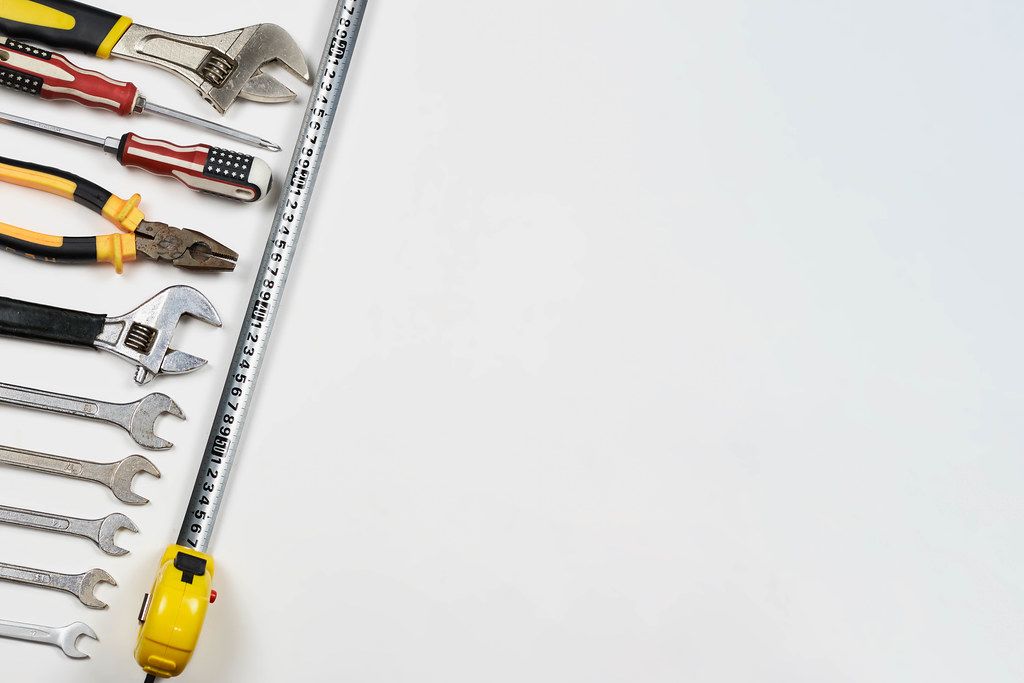 Labor day background. Top view of many handy working tools on the white background