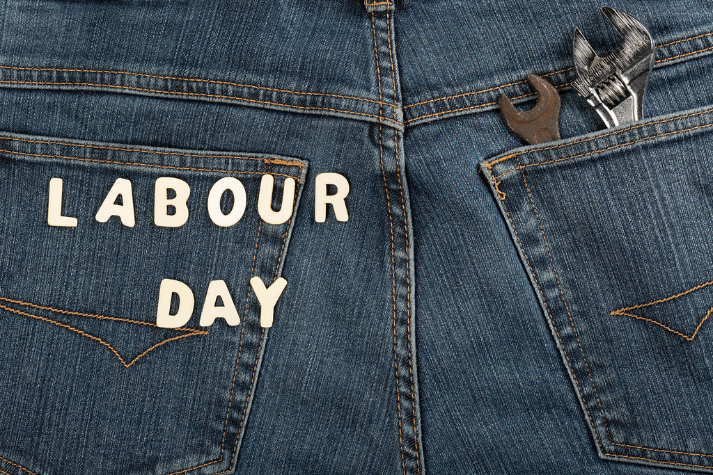Labor day from wooden letters on denim with wrenches in pocket
