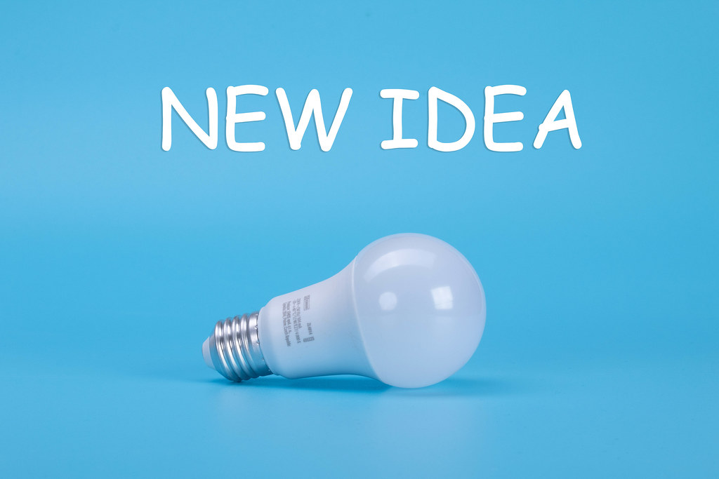 Light bulb with New idea text on blue background
