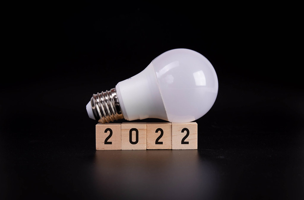 Lightbulb and wooden blocks with 2022 text on black background