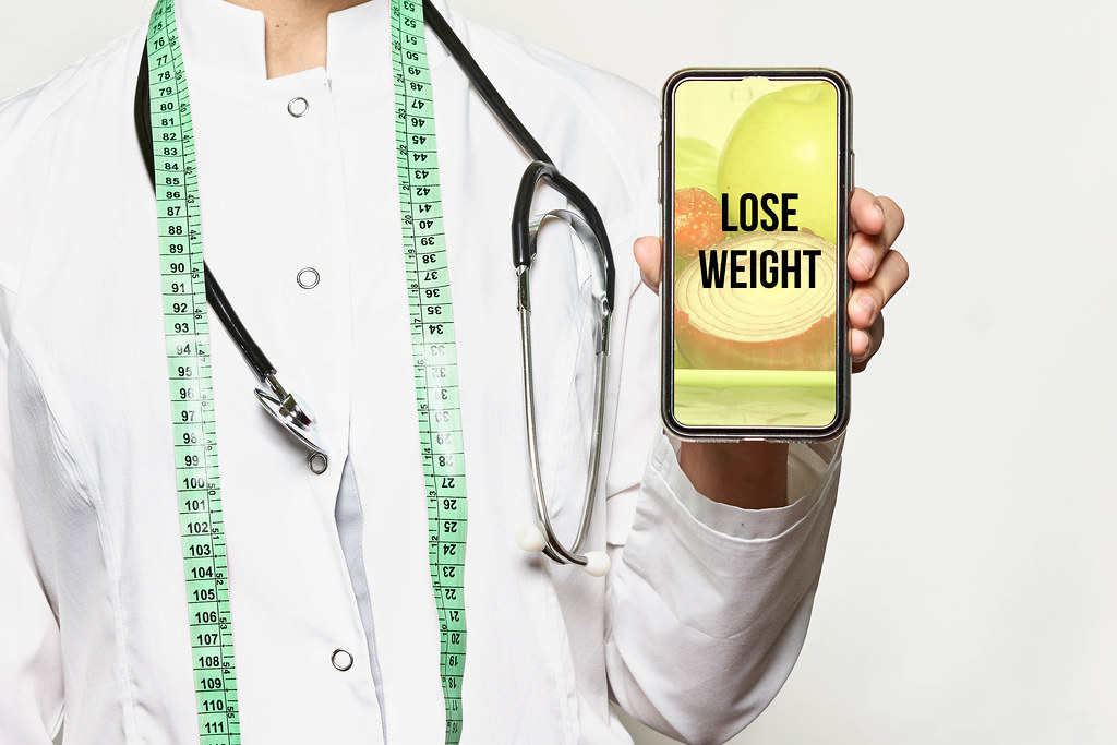 Lose weight concept. Dietitian with smartphone