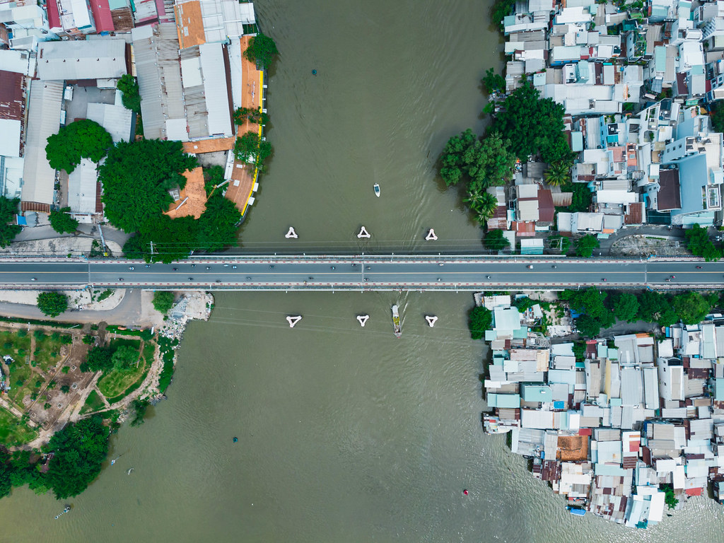 Luftaufnahme einer kleinen Brücke über einen Fluss zwischen zwei Stadtbezirken in Ho Chi Minh Stadt, Vietnam