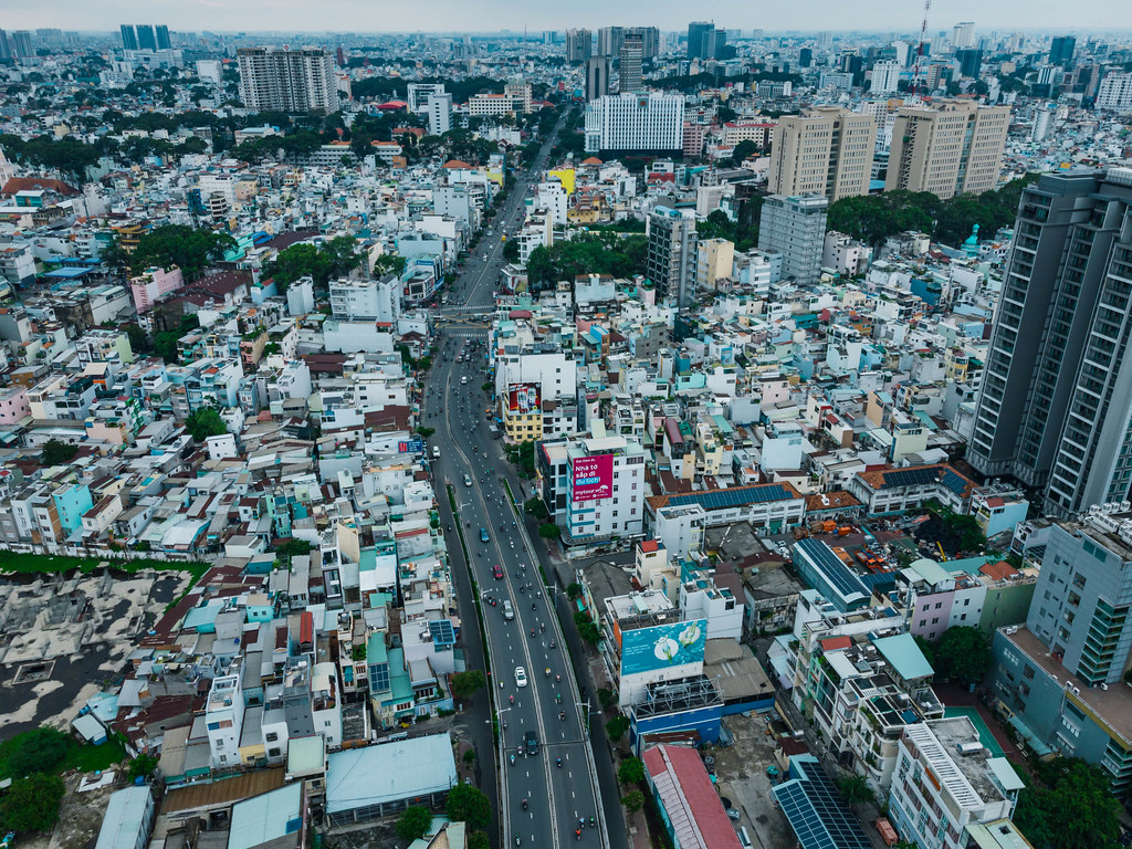 Luftaufnahme von einer Straße mit viel Verkehr, vielen Häusern und Regierungsgebäuden in Distrikt 1 in Ho Chi Minh Stadt, Vietnam