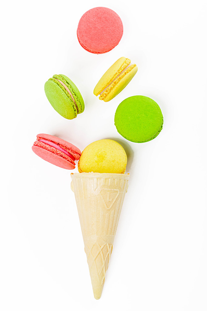 Macaroon on white background, sweet and colorful dessert with waffle cone, top view