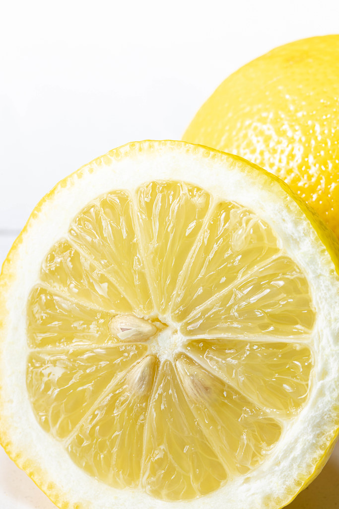 Macro of sliced lemon above white background with copy space