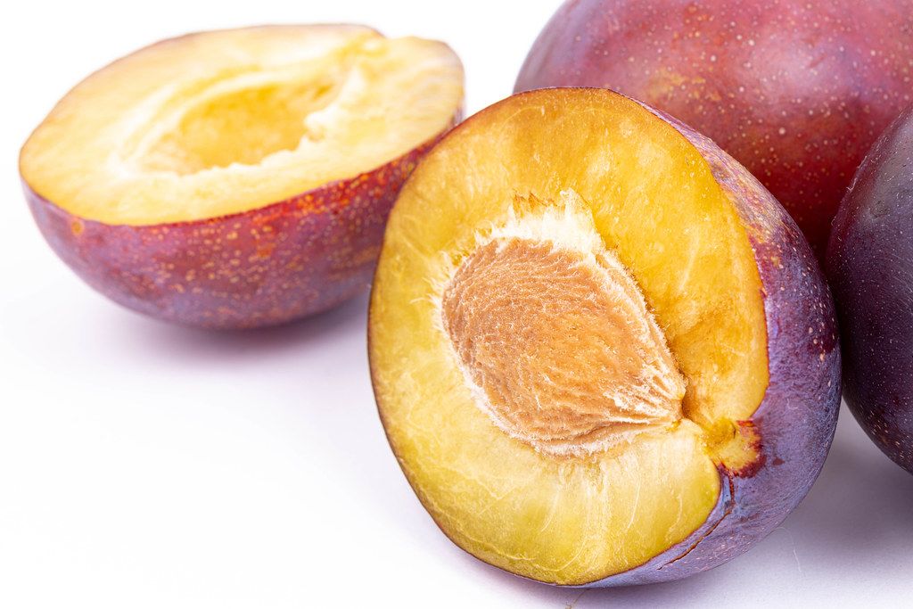 Macro of sliced Plums above white background
