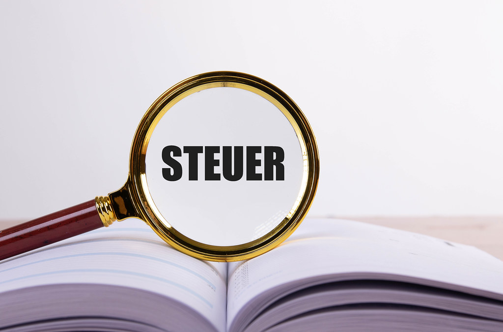 Magnifying glass and book with Steuer text
