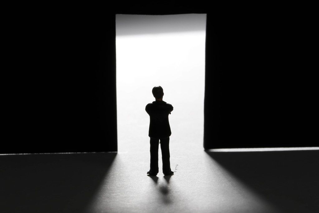 Man silhouette standing front of a door