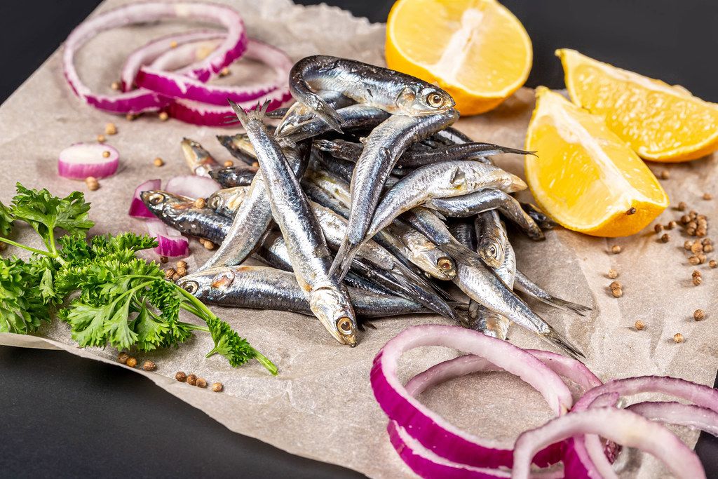 Marinated small fish with spices, purple onion, lemon and parsley
