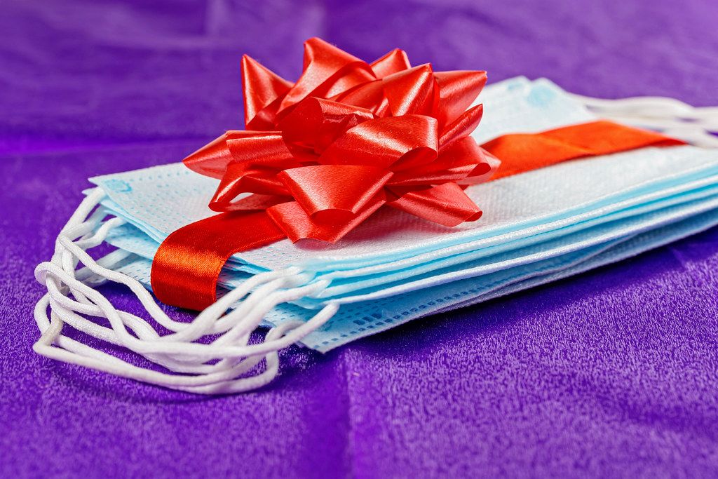 Masks as a gift, tied with a red ribbon with a bow on a purple background