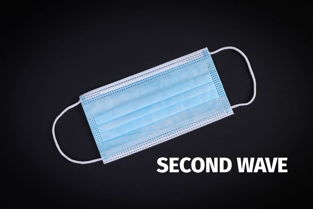 Medical face mask on black background with Second Wave text