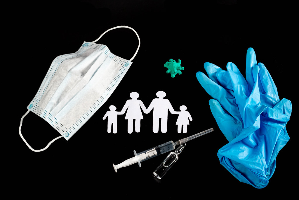 Medical mask, syringe, gloves, ampoule and family silhouette on black, health protection concept
