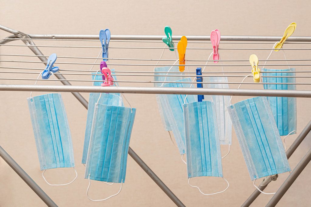 Medical masks hang on a dryer with clothespins