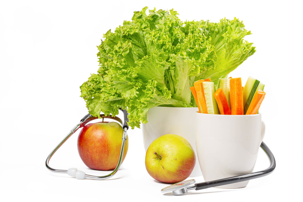 Medical stethoscope with fresh vegetables and apples