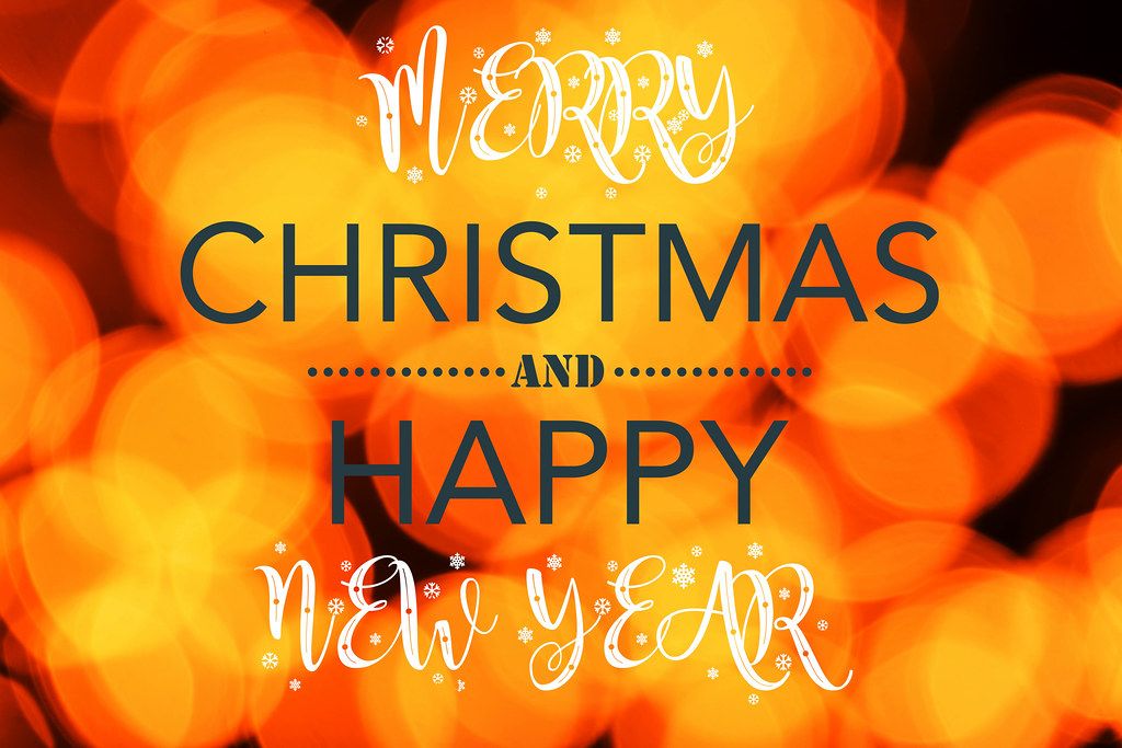 Merry christmas and happy new year on orange blurred background