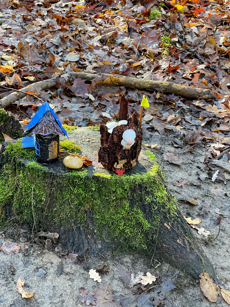 Metal containers decorated and recycled into a toy house with blue roof and a castle with shells