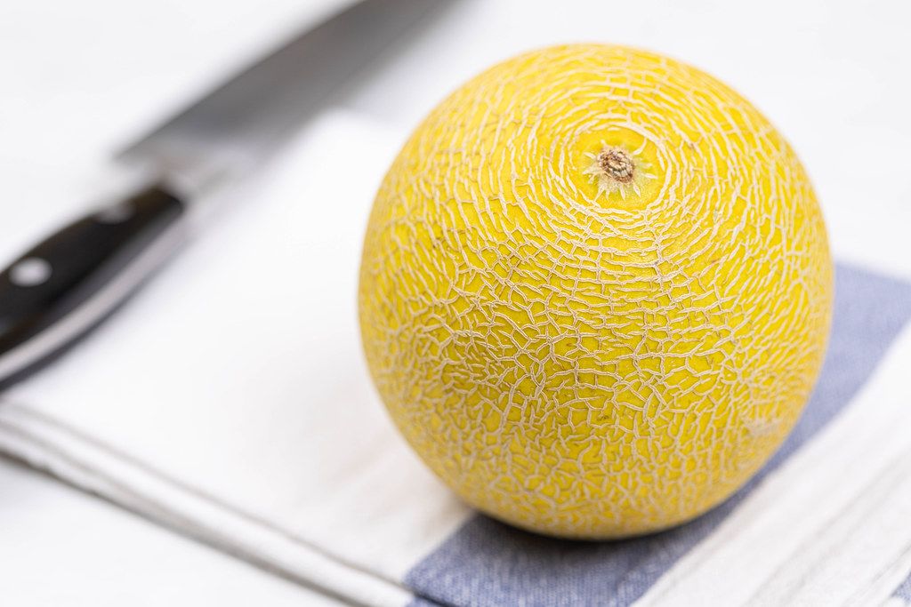 Mini Melon on the table with knife in the background