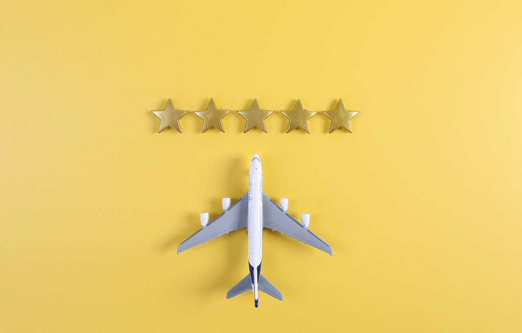 Miniature airplane with five golden stars on yellow background