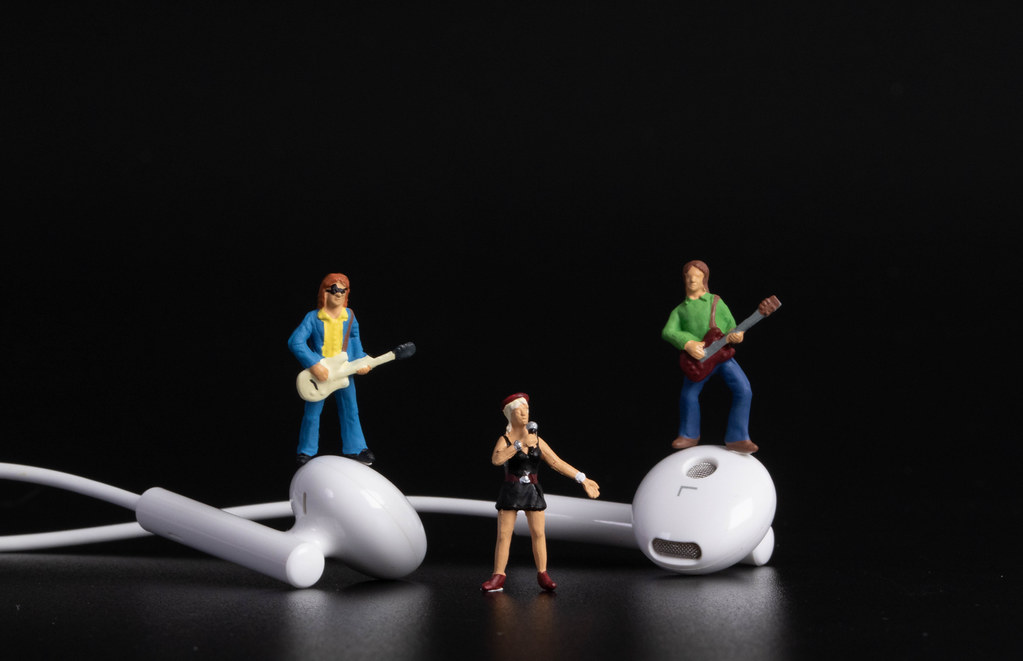 Miniature band with earbuds on black background
