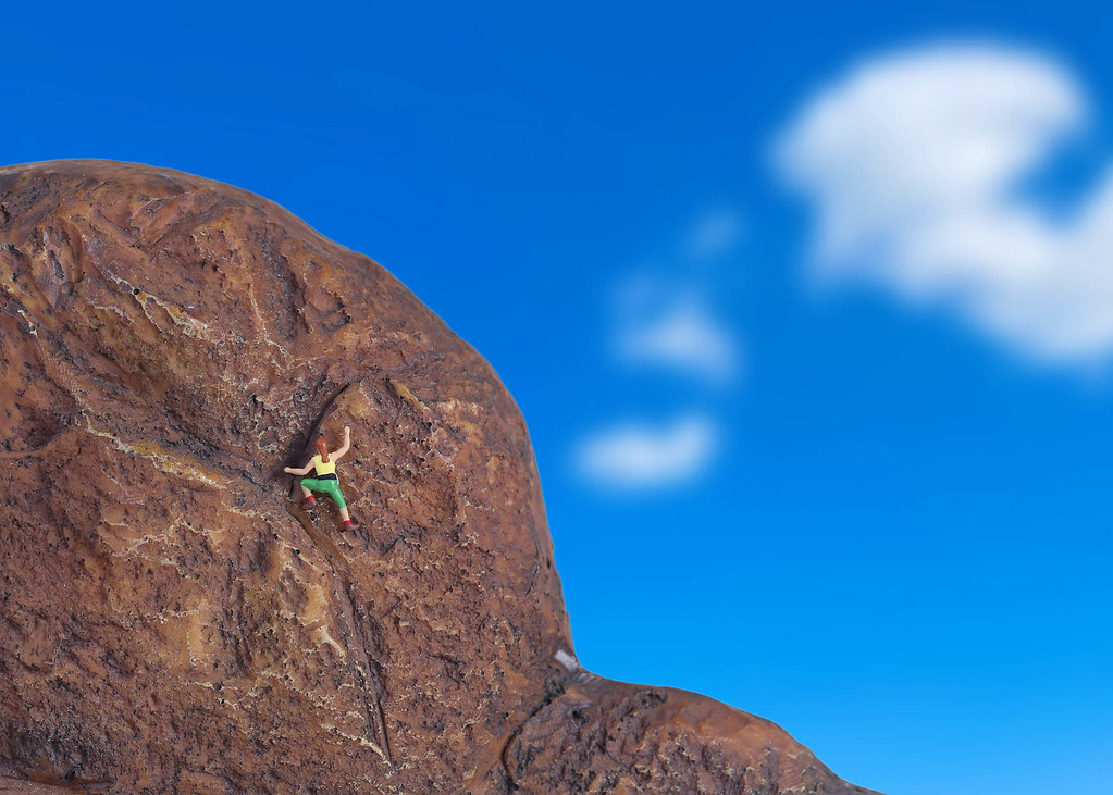 Miniature climber climbing on rock