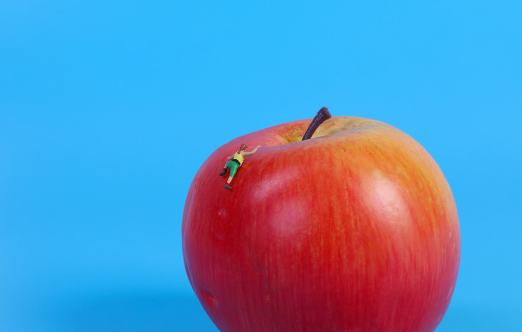 Miniature climber on red apple