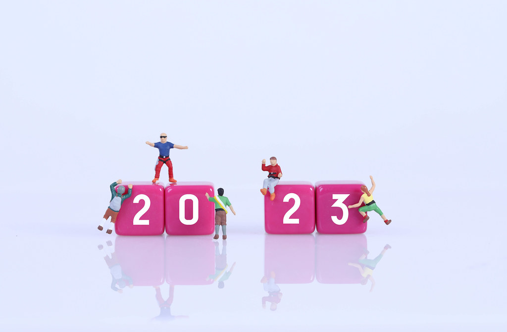 Miniature climbers on blocks with 2023 text on white background