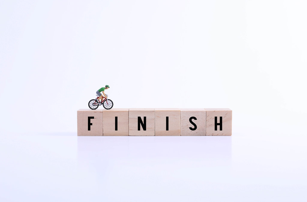 Miniature cyclist on wooden blocks with Finish text