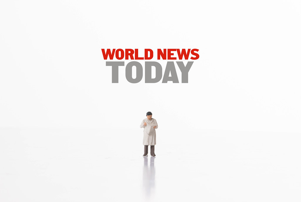 Miniature man reading newspaper and World News Today text - Creative ...