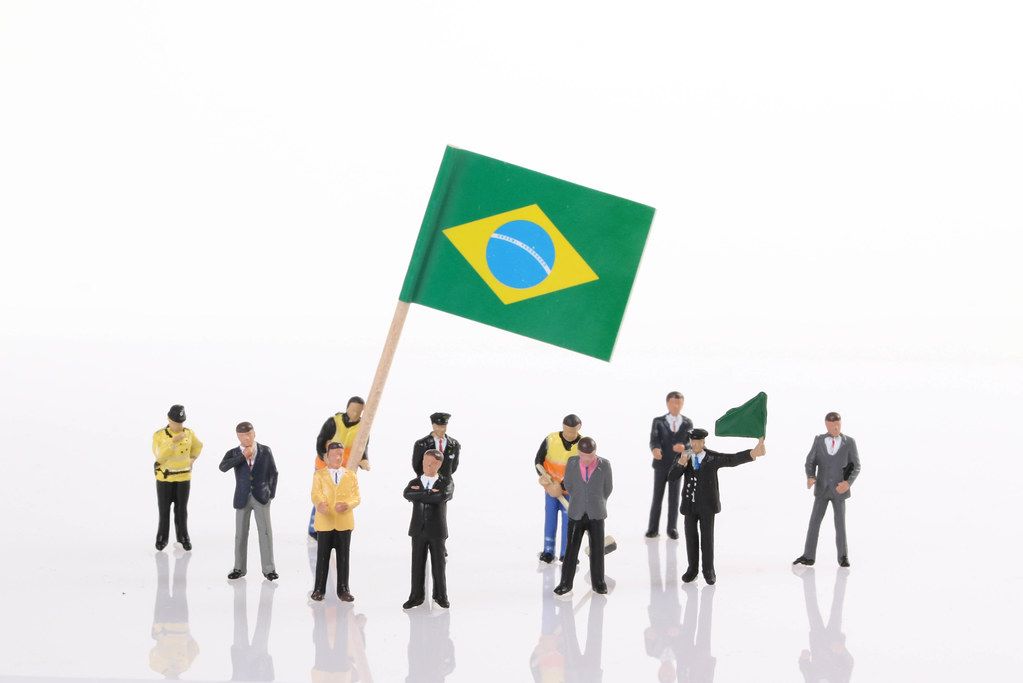 Miniature people with flag of Brasil