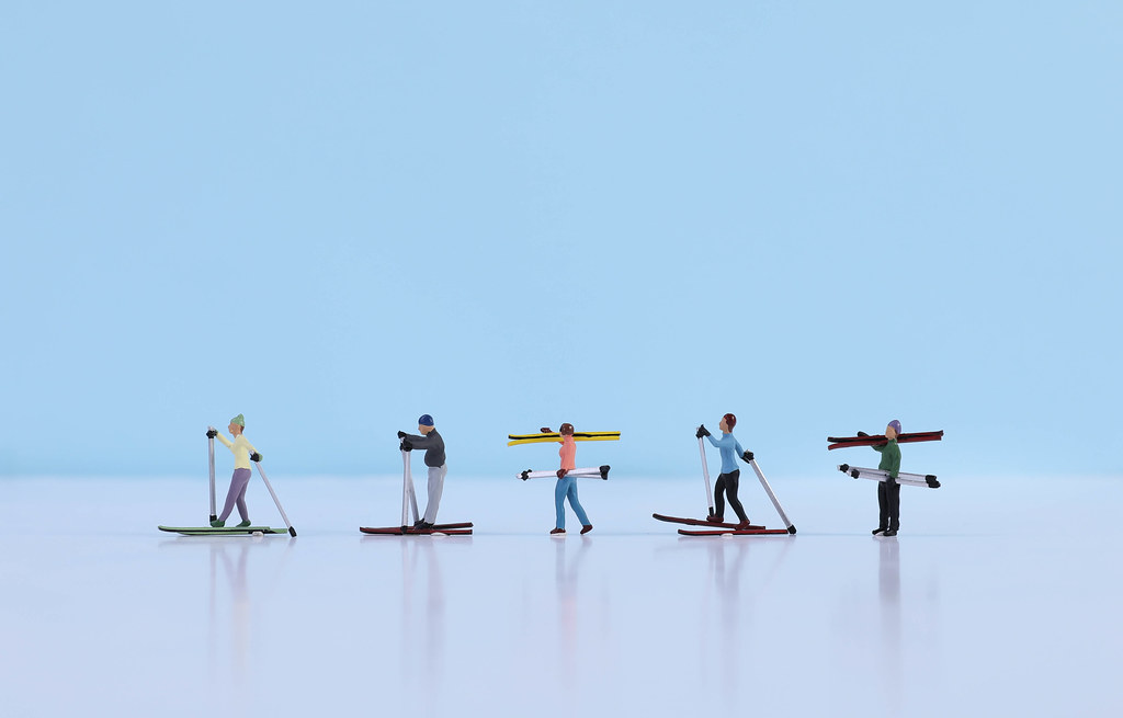 Miniature skiers on light blue background