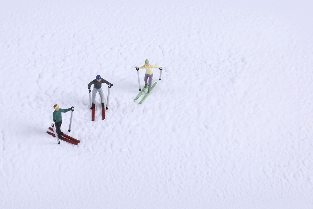 Miniature skiers on snow