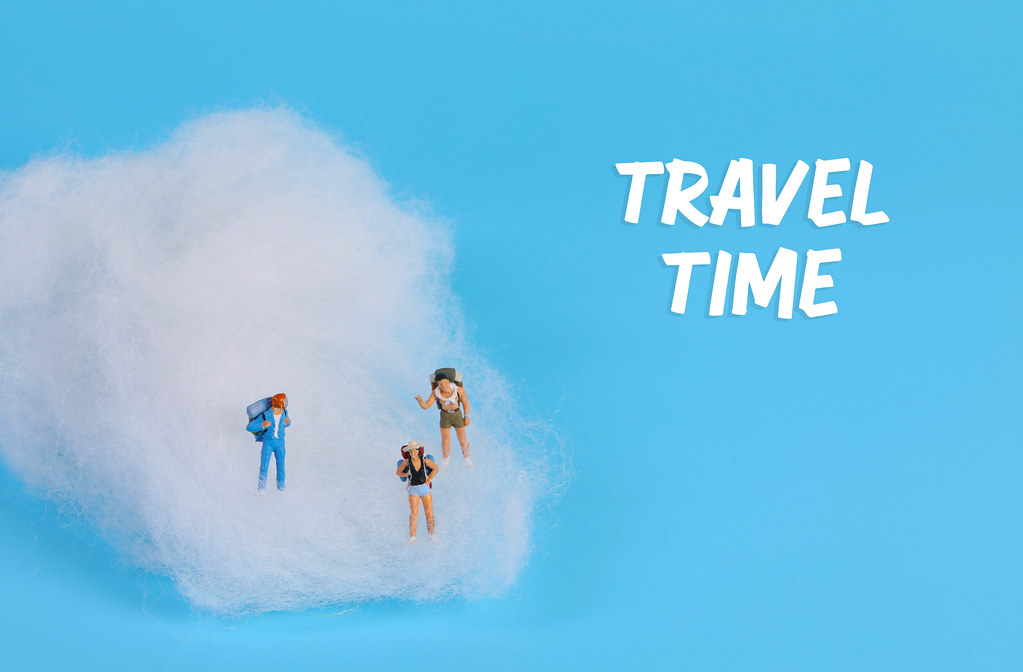 Miniature travelers on clouds and Travel Time text