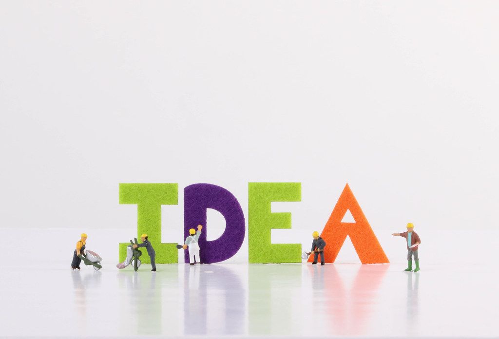 Miniature workers with Idea text on white background