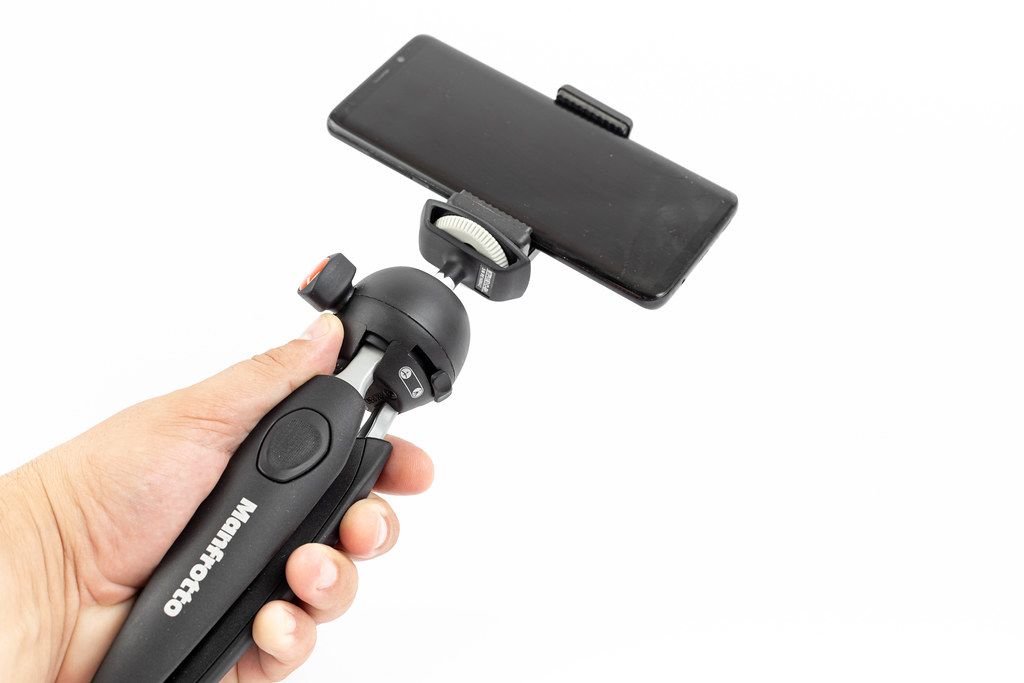 Mobile Phone mounted on Desktop Manfrotto Tripod in the hand
