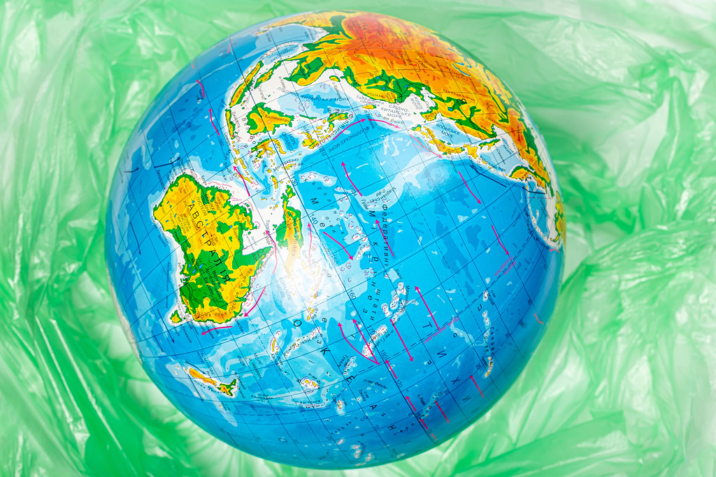 Model of the planet earth on the background of polyethylene plastic disposable trash bag, concept for pollution and environmental protection