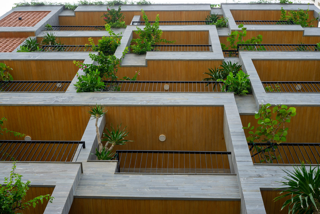 Modern Exterior of a Hotel with Wooden Elements, Balconies and Plants in Da Nang, Vietnam