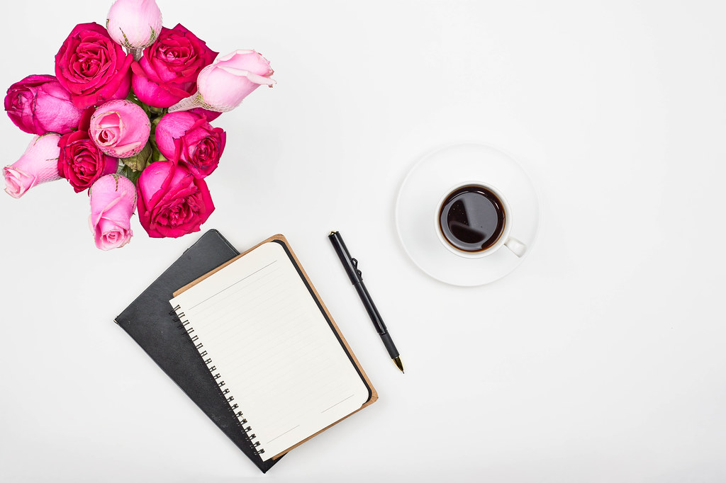 Modern feminine working place with coffee and roses. Work from home concept