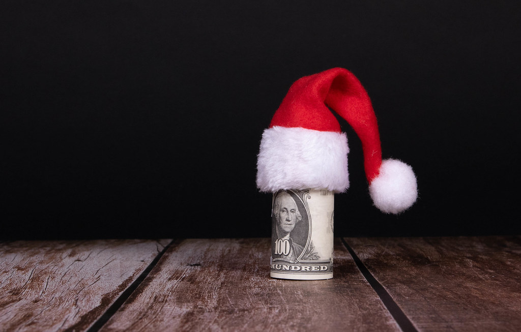 Money roll with Christmas hat on black background