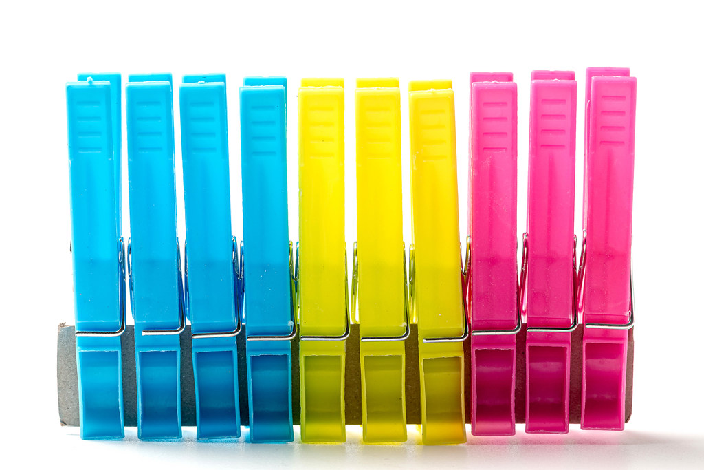 Multi-colored clothespins in a row on a white background