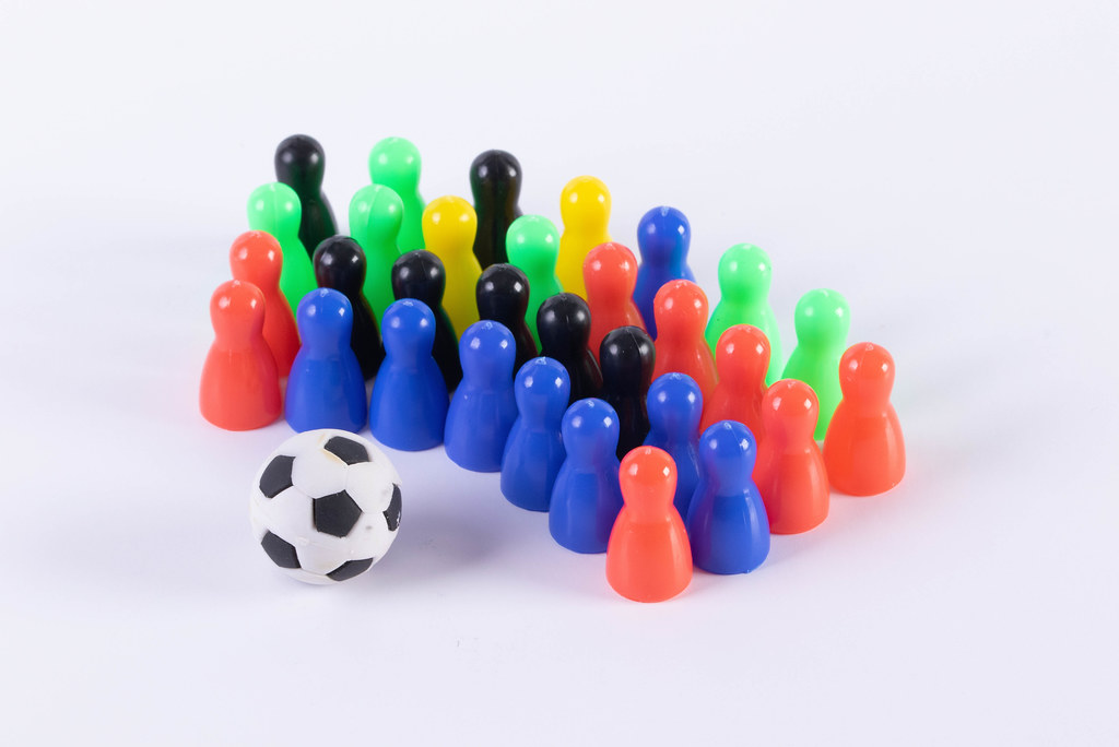 Multi colored pawn figures with soccer ball