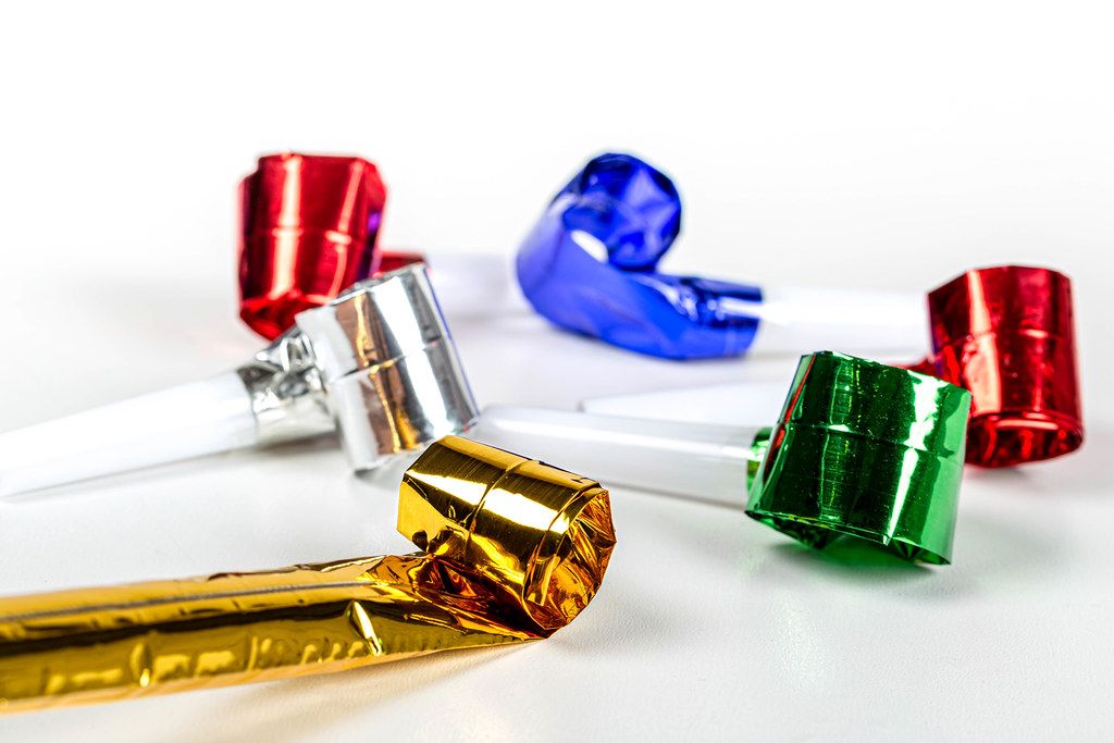 Multicolored air whistles on a white background