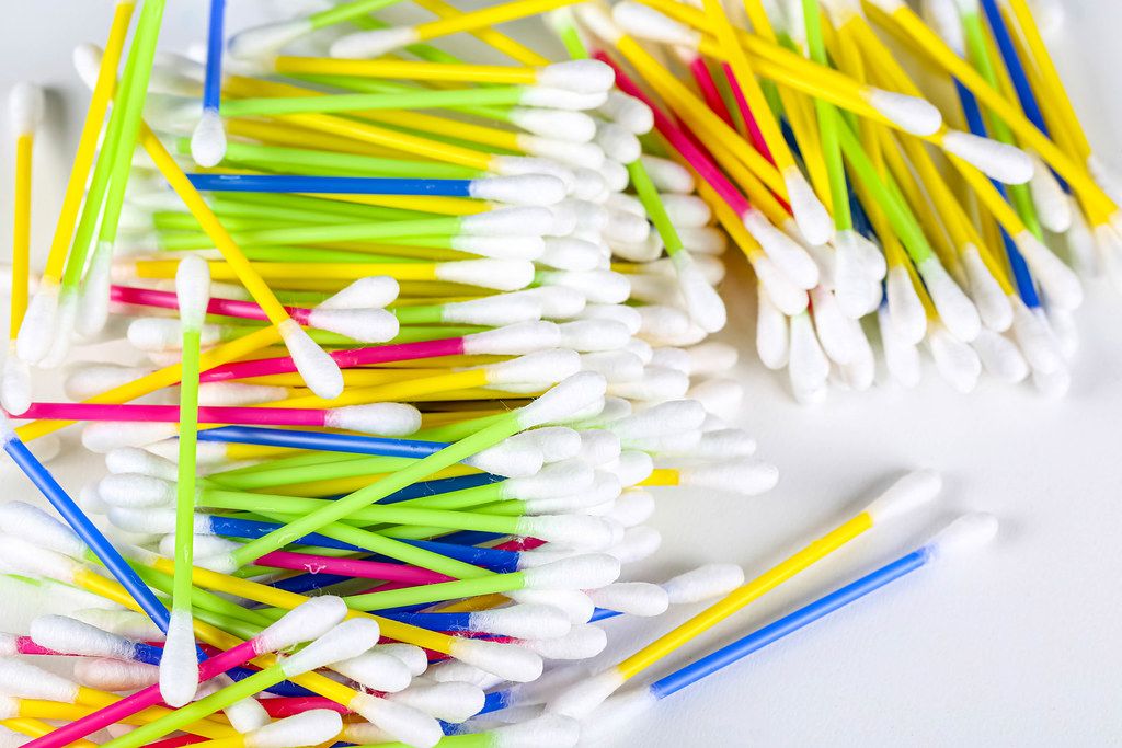 Multicolored cotton swabs on white background