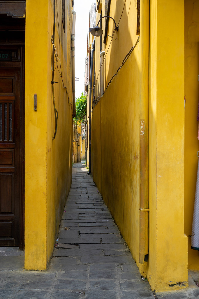 Narrow Alleyway in between two Yellow Buildings in the Ancient Town of Hoi An, Vietnam