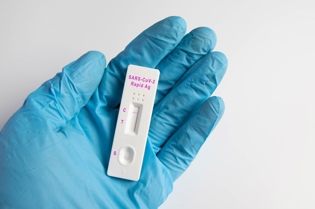 Negative Covid-19 / SARS-CoV-2 rapid antigen test held in doctors medical blue glove against white background