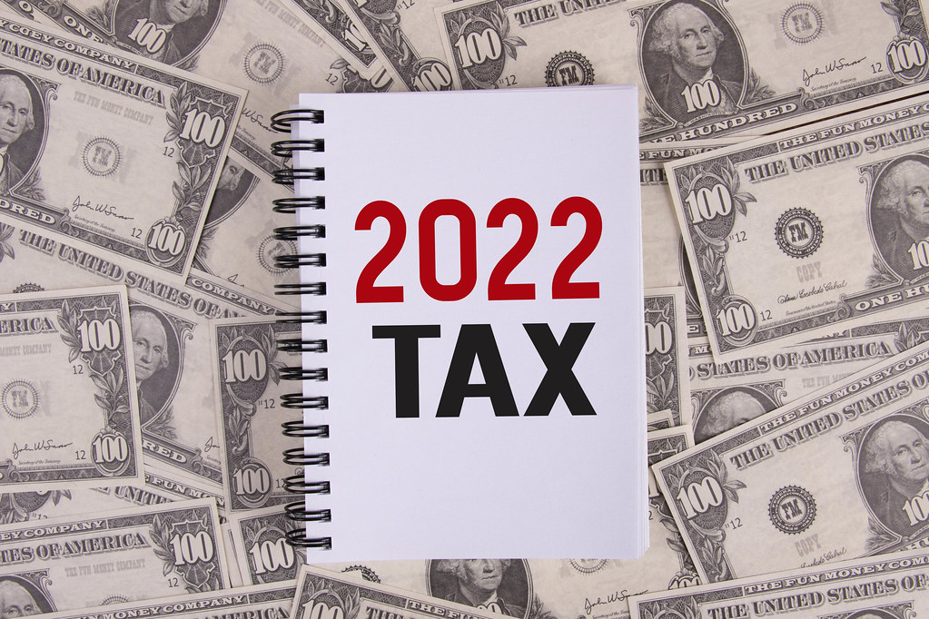 Notebook with 2022 Tax text on dollar banknotes